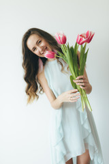 Beautiful girl hugging bouquet of pink tulips, girl and tulips