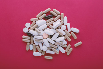 Different pills on pink background