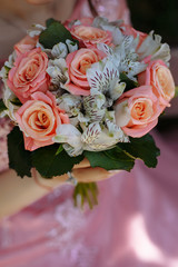 Wedding bouquet on the background of a wedding dress.