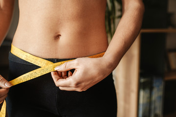 woman measuring her waist after dieting