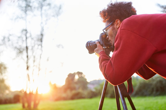 Landscape photographer with camera while photographing