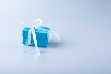 Blue gift box with white ribbon bow on white background