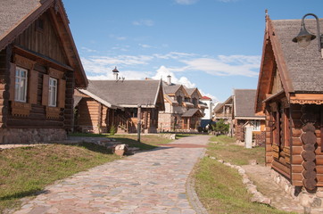 Beautiful wooden and brick houses in the modern village. Spring sunny day in the village under clean and blue skies.
