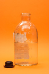 open vintage medical bottle on orange background