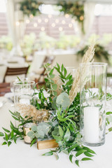 banquet table is decorated with plates, cutlery, glasses, candles and flower arrangements