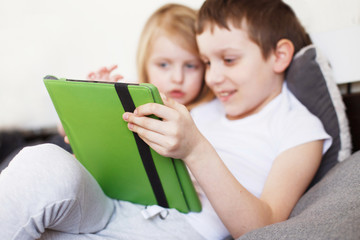 happy children playing with tableton bed . Distance learning online education for kids. Quarantine and self-isolation.