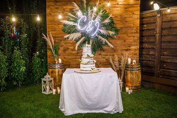wedding cake stands on a served table and is decorated with flowers