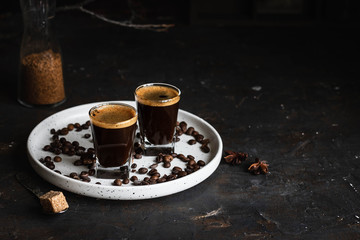 Espresso coffee in two glasses. Dark background. Dark style