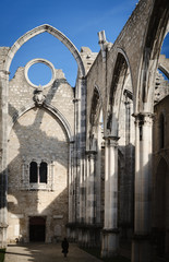 Small distant walking woman in the ruins of the ancient convent of Carmo in Lisbon, Portugal,...