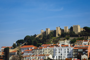 Fototapeta na wymiar View of the Sao Jorge castle, Landmark of Lisbon, Porgugal, with clear blue sky in background