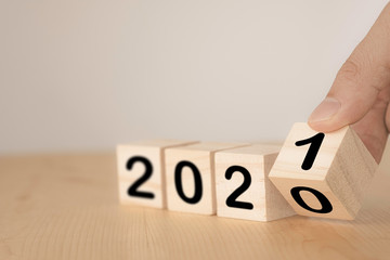 Hand flipping wooden blocks for change year  2020 to 2021 . New year and holiday concept.