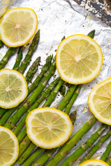Asparagus and lemon slices on a baking tray