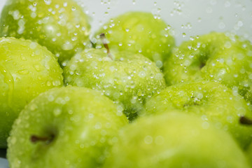 Washing fruit. Wet apples in the shower and water drops. Girl washes fruits and vegetables for the prevention of coronavirus covid-19 2019-ncov