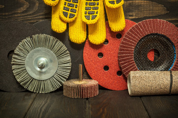 The set of abrasive tools and yellow work gloves on black vintage wooden boards wizard is used for grinding items