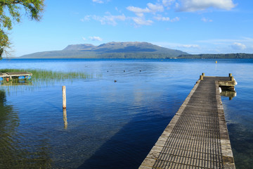 The jetty at Rangiruru Bay on Lake Tarawera, New Zealand. On the other side of the lake is Mount Tarawera, a dormant volcano 