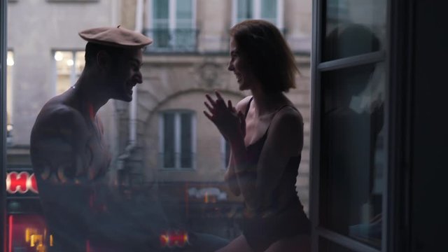 loving couple in underwear kisses by the window in apartment in Paris