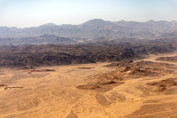 Fototapeta na wymiar Aerial view of the Sahara desert between the river Nile and the Red Sea, seen from the airplane window. Egypt, Africa