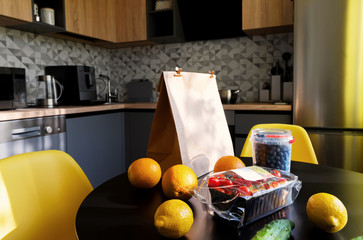 Bag with different food fruits and vegetables on modern kitchen