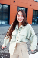 young pretty teenage girl posing cheerful happy smiling wearing street style outside in europe city, lifestyle people concept