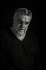 Portrait of mature man with beard on dark background