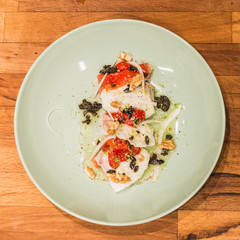 Ensalada de bacalao confitado, con tomate, cebolla y nueces