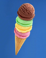 Mint strawberry and chocolate ice cream scoops or balls in cone isolated on blue sky background including clipping path.	