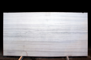 A slab of natural stone of gray-white color with longitudinal stripes is called Nestos Grey