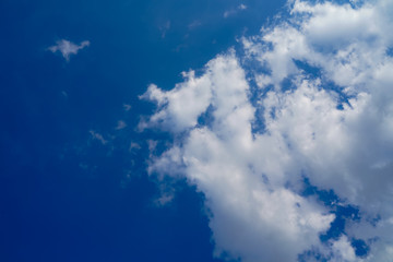 Close up fluffy white cloud formation on the right frame ,good space advertising or banner design, a beautiful blue sky background.