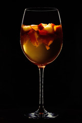 glass of wine with fruit on a black background