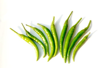 In the photo green  chili peppers.  Pods on a white background.