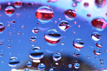 shiny clear water point attached to a glass reflects the same color as the color on the glass into a beautiful background as decoration