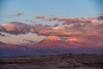 Fototapeta na wymiar pink glow of sunset on snow capped volcano