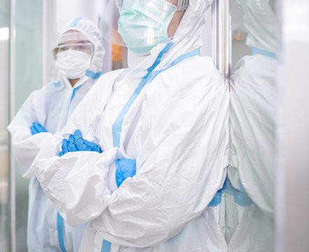 Asian woman doctor in personal protective suit or PPE wearing mask and goggles, standing with arms folded fighting against covid-19 outbreak. Medical, coronavirus, covid-19 and healthcare concept.