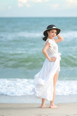 Fototapeta na wymiar Beautiful women in white dress happily strolling at the beach, beautiful women dressed in white bride