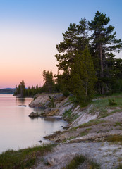 Sunset over the forest and shoreline of Yellowstone Lake 