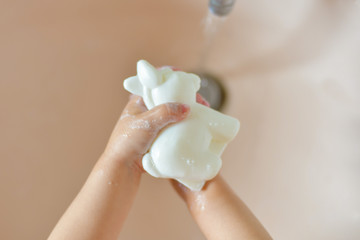 A child washes his hands with soap at home during an epidemic