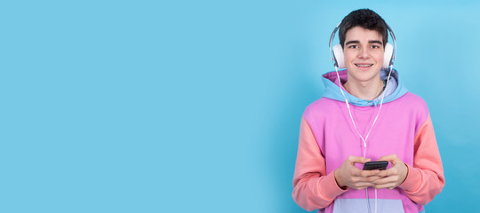 teenager with headphones and mobile phone isolated on color background