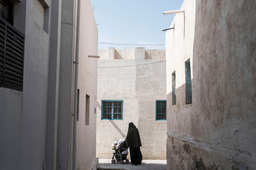Fototapeta na wymiar woman walking down back alley in burka