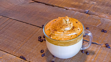 Whipped Korean style Dalgona Coffee on a rustic wooden background.
