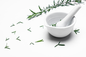 A mortar grinder drugs with herbs  - Rosemary isolated on white background.  For copy space.