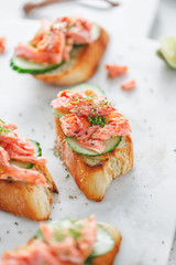 Toasts with fresh cucumber and smoked salmon served with lime shavings.