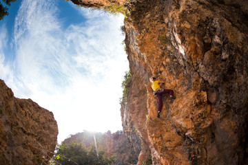 A strong rock climber is training on Turkish rocks, A woman climbs a climbing route.