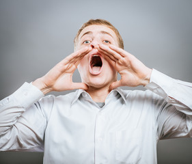 Photo of shouting man with his palms open by mouth looking upwards