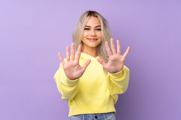 Teenager girl wearing a yellow sweatshirt over isolated purple background counting ten with fingers