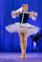 Young girls ballerina in a blue and white costume dancing performance on stage in a theater © Kozlik_mozlik