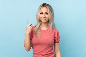 Teenager girl over isolated blue background pointing with the index finger a great idea