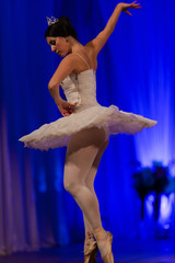 woman ballerina in a white tutu dancing performance on stage in a theater on a blue background © Kozlik_mozlik