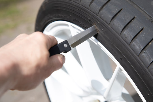 sharp knife pierced into a car tire