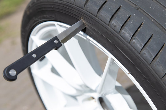 Messer steckt in Autoreifen Reifen gestochen