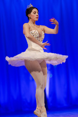 woman ballerina in a white tutu dancing performance on stage in a theater on a blue background